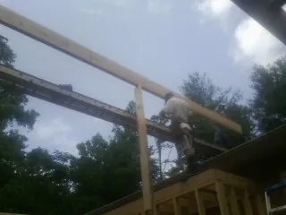 Carpenter setting a ridge beam over a new addition frame — Ice Dam Removal by Roofing Brothers in Black Mountain