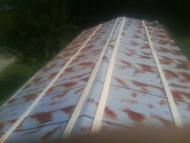 Rusted metal roof panels with new wood purlins before replacement — Storm Damage Roof Repair in Black Mountain by Roofing Brothers