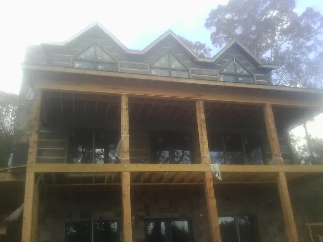 Dormers and porch framing on a large log home under construction — Roof Coating work by our crew in Black Mountain