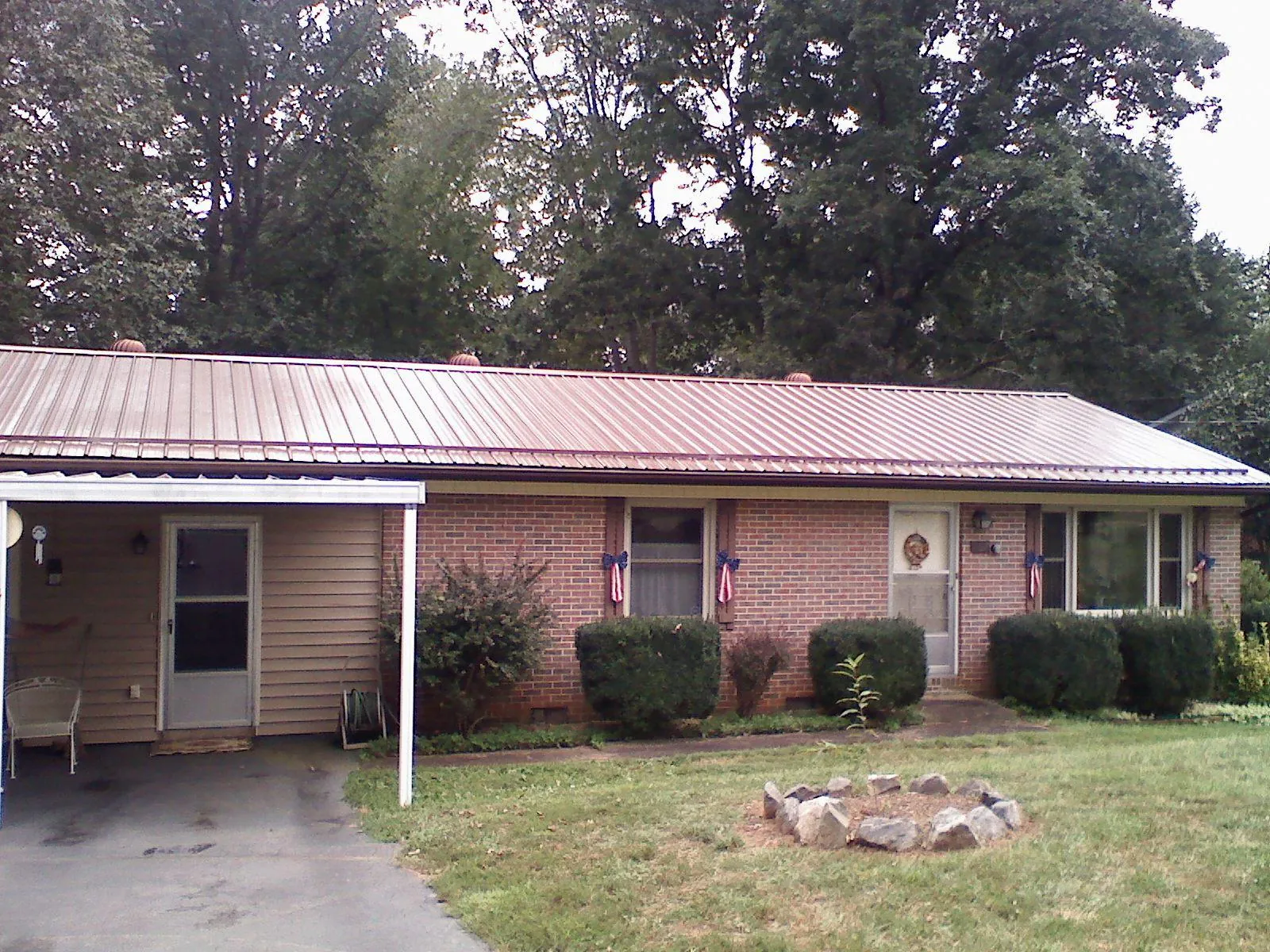 Bronze metal roof and carport on a brick ranch home — Roof Repair work by our crew in Black Mountain