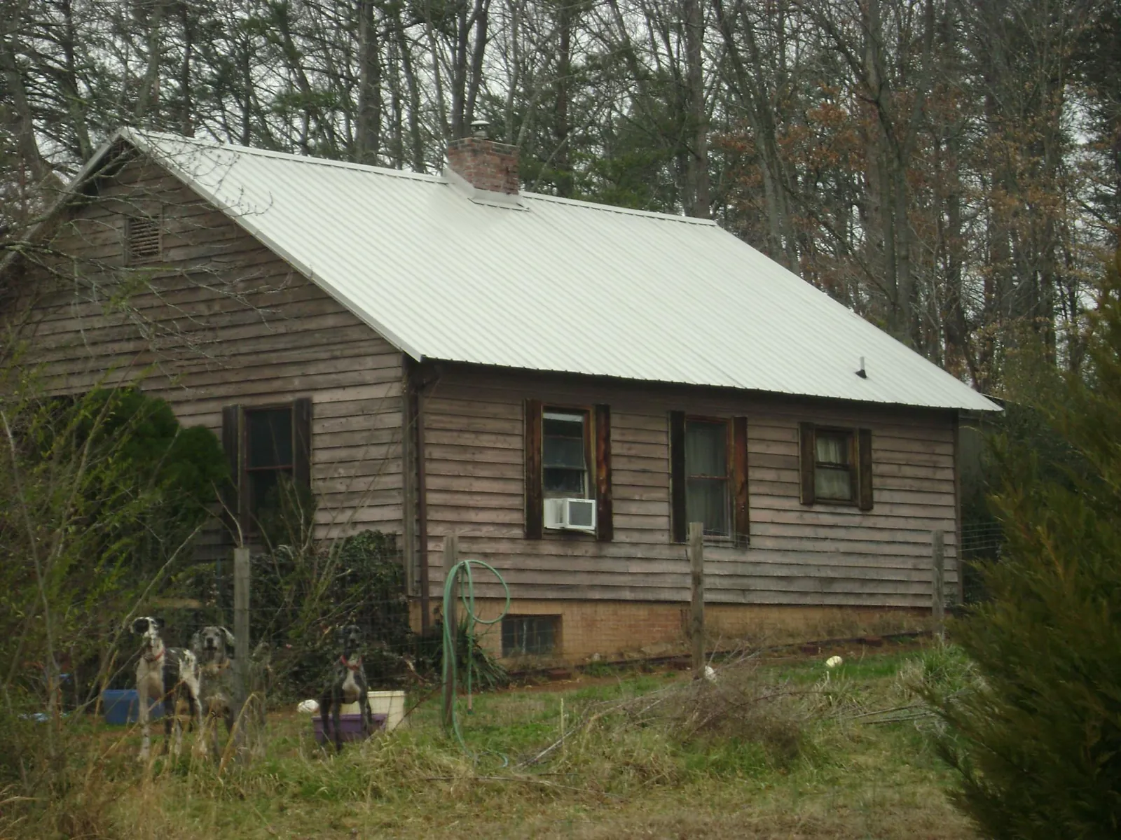 White metal roof on an old wood sided farmhouse, from a Metal Roof Installation job in Black Mountain